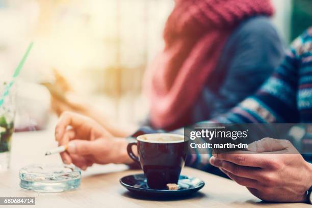 paar im café sms - zigarettenpause stock-fotos und bilder
