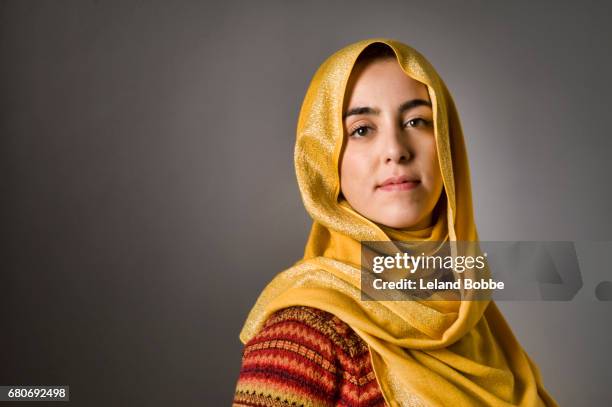 portrait of young middle eastern woman wearing a hijab - kopftuch stock-fotos und bilder