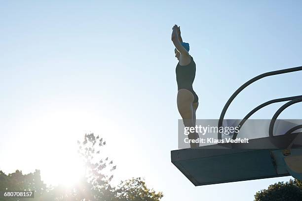 female diver jumping from platform - high diving platform stock pictures, royalty-free photos & images