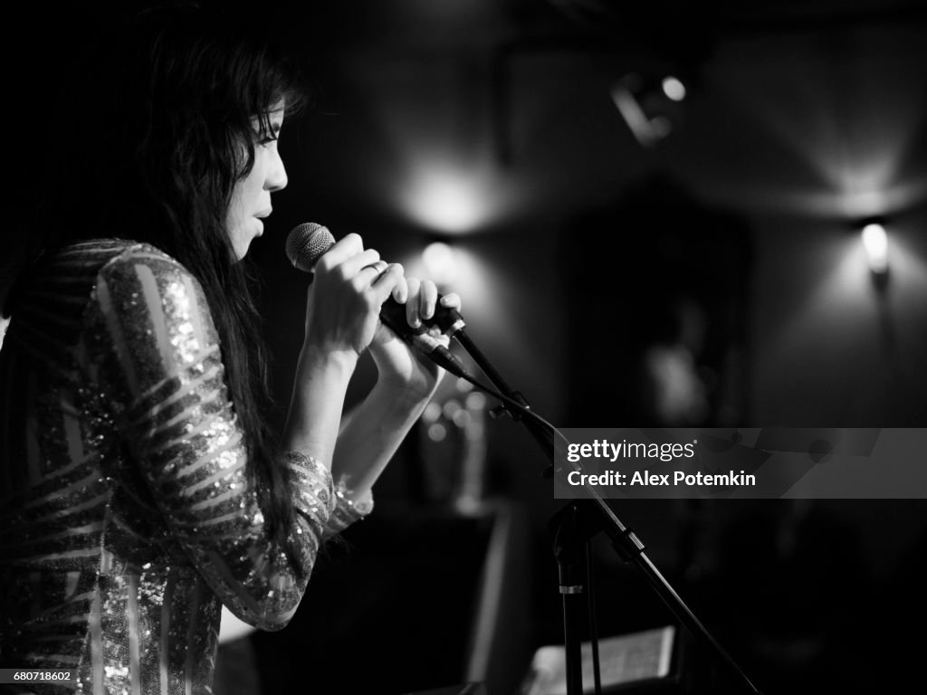 Young woman, musician, singer and performer, singing on the stage.