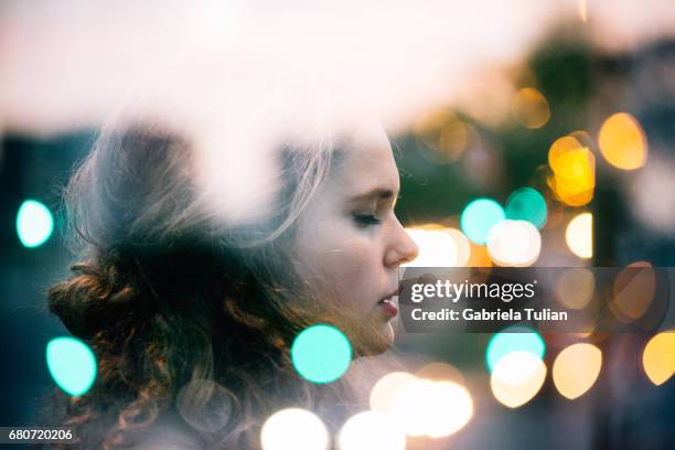 double exposure of young woman with bokeh city lights. - double exposure portrait city stock-fotos und bilder