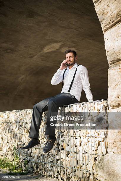 businessman sitting and talking on mobile phone, munich, bavaria, germany - suspenders 個照片及圖片�檔