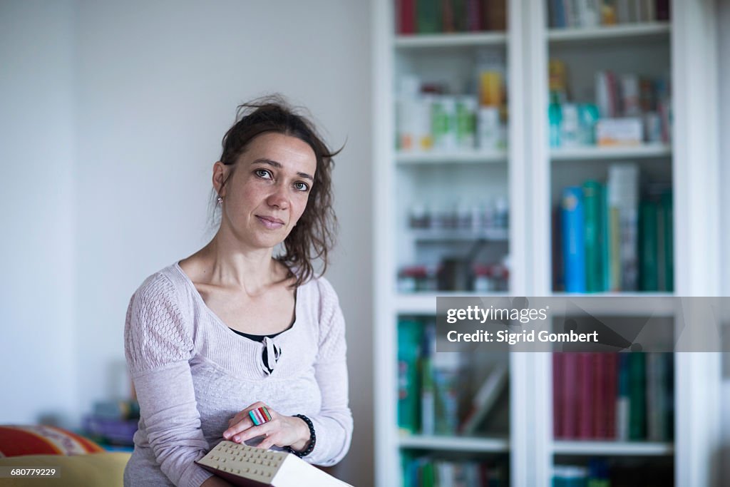 Female healer reading medical book, Freiburg im Breisgau, Baden-Württemberg, Germany