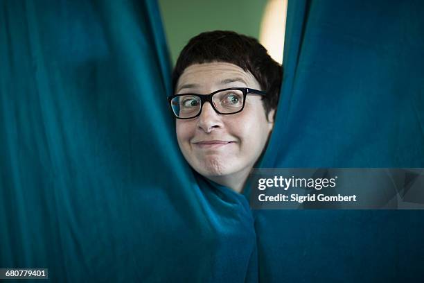 mature woman peeking from curtain in the office, freiburg im breisgau, baden-württemberg, germany - gesicht verstecken stock-fotos und bilder