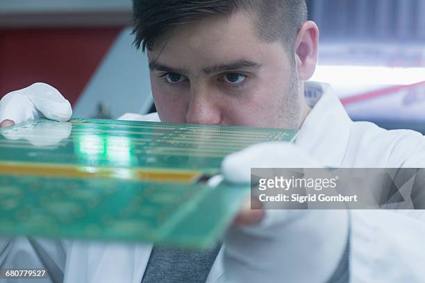male engineer examining circuit board in industry, hanover, lower saxony, germany - newtechnology stockfoto's en -beelden