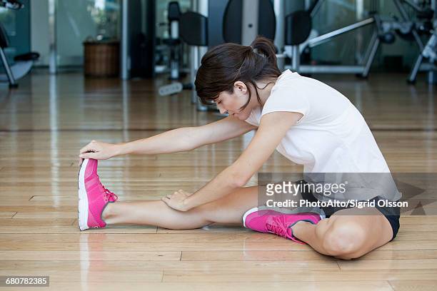 woman doing stretches on the floor in health club - 前屈運動 ストックフォトと画像