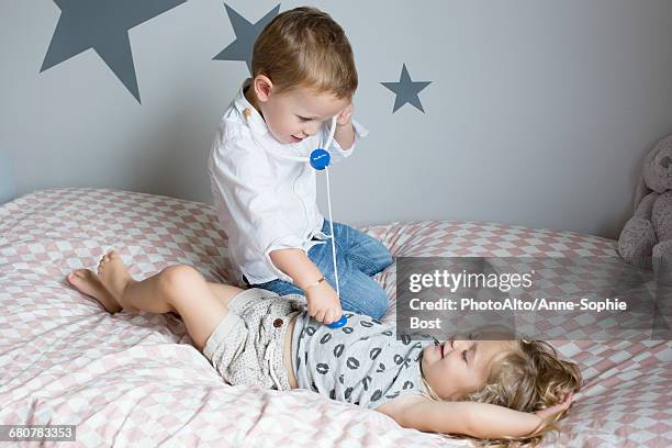 children playing doctor with toy stethoscope - vestita da dottoressa foto e immagini stock