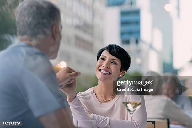 affectionate couple holding hands and drinking white wine at urban sidewalk cafe - 50s diner stock pictures, royalty-free photos & images