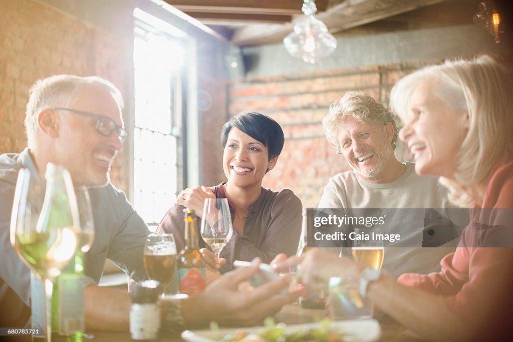 Couples dining and using cell phone at restaurant table