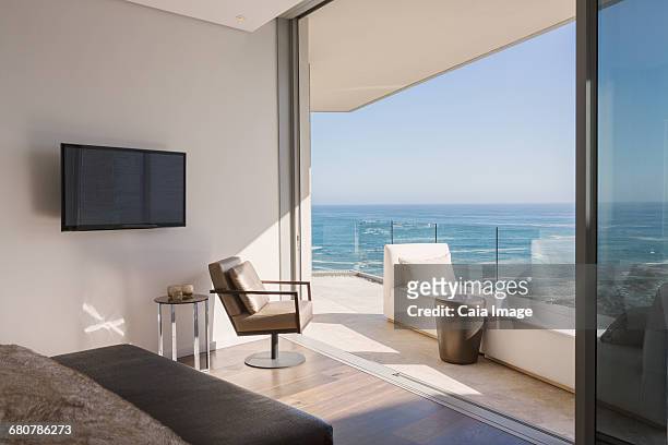 bedroom open to sunny luxury home showcase balcony with ocean view - beach house balcony stock pictures, royalty-free photos & images