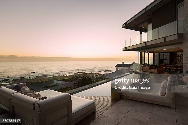 tranquil sunset ocean view beyond modern luxury home showcase patio - beach house exterior stock pictures, royalty-free photos & images