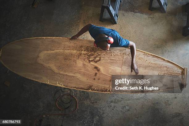 craftsman making paddleboard in workshop, overhead view - kunstnijverheid stockfoto's en -beelden