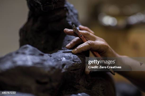 cropped view of sculptor in artists studio creating sculpture with hand tool - sculptor stock pictures, royalty-free photos & images