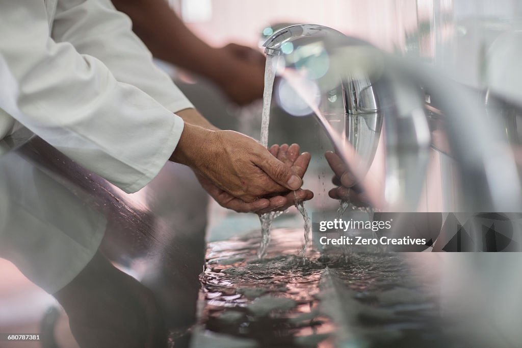 Close up of two factory workers washing hands in packaging factory