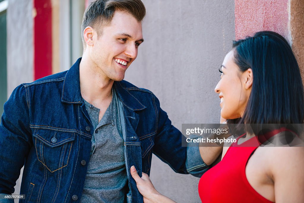 Young couple chatting against wall