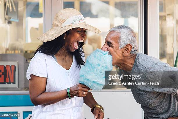 senior couple eating cotton candy, laughing, long beach, california, usa - algodón de azúcar fotografías e imágenes de stock