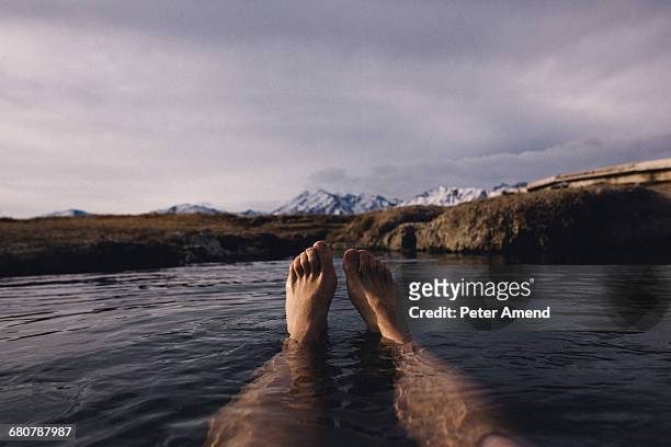 legs of man floating in water on lake, mammoth lakes, california, usa - mammoth lakes stock pictures, royalty-free photos & images