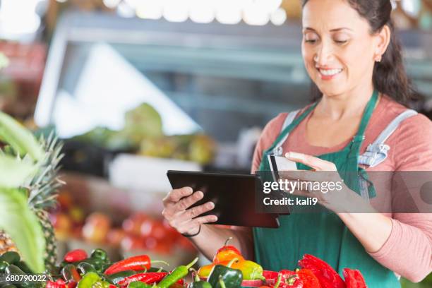trabajador en producir mercado procesamiento de tarjeta de crédito - puesto de mercado agrícola fotografías e imágenes de stock