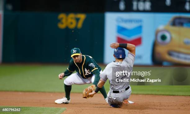 Adam Rosales of the Oakland Athletics forces Rougned Odor of the Texas Rangers out at second during the game at the Oakland Alameda Coliseum on April...