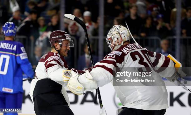 Elvis Merzlikins, goaltender of Latvia celebrate with team mate Rihards Bukarts after the 2017 IIHF Ice Hockey World Championship game between Italy...