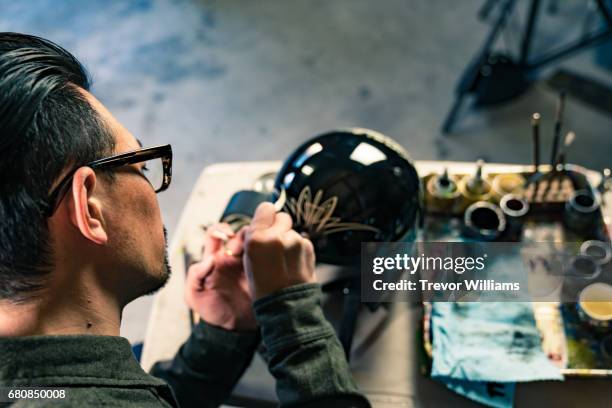 an artist customizing a motorcycle helmet and painting it by hand - customized stock-fotos und bilder