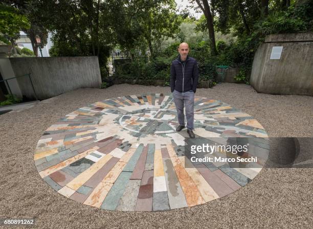 Artist Gal Weinstein poses for a picture standing on "Marble Sun" at the Israeli pavilion on May 9, 2017 in Venice, Italy. The 57th International Art...