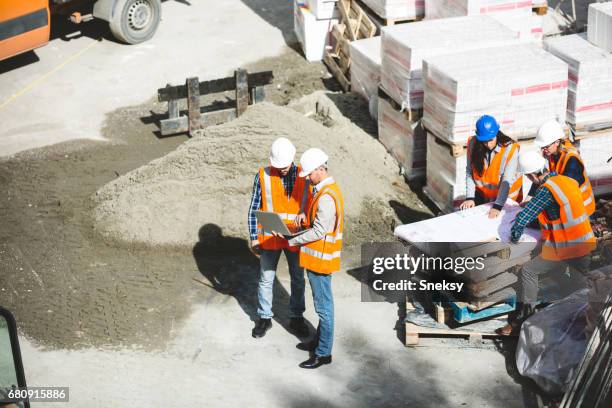 arbeiter und ingenieure auf baustelle - aerial view construction workers stock-fotos und bilder