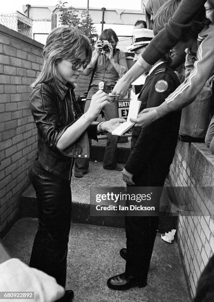 Suzi Quatro signs autographs for fans at Brands Hatch race circuit, 1974.