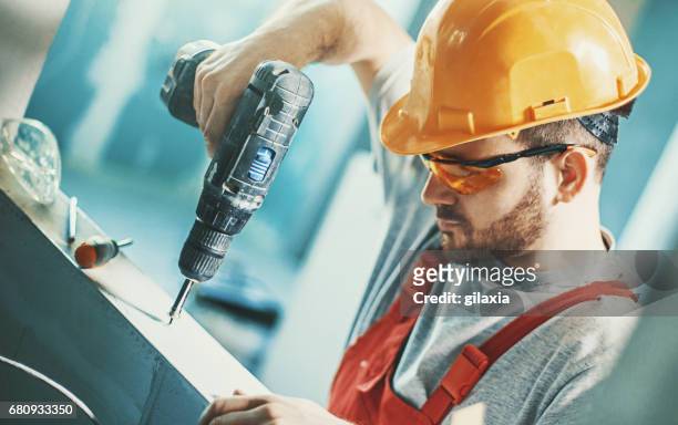 construction worker assembling a drywall. - electric screwdriver stock pictures, royalty-free photos & images