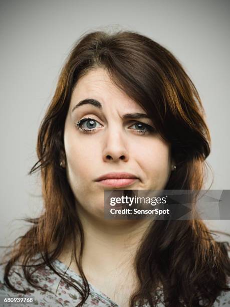 geërgerde jonge wijfje tegen grijze achtergrond - confused woman stockfoto's en -beelden