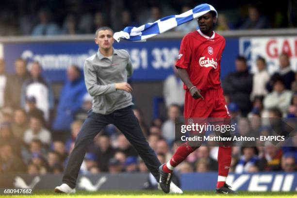 An Everton fan throws his blue and white flag on Liverpool's Salif Diao