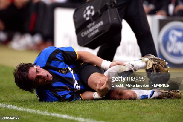 Inter Milan's Francesco Coco clutches his leg in agony as the physio comes to his aid