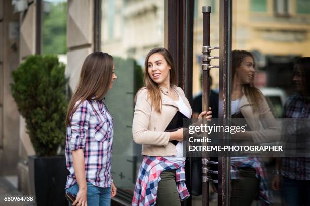 jeunes filles dans la rue avec tablette - entering photos et images de collection