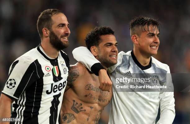 Gonzalo Higuain, Dani Alves and Paulo Dybala of Juventus celebrate victory following the UEFA Champions League Semi Final second leg match between...