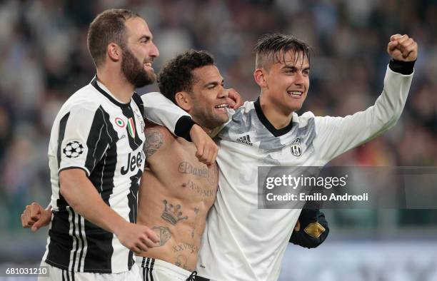 Paulo Dybala of Juventus FC celebrates with his team mates Daniel Alves da Silva and Gonzalo Higuain the victory at the end of the UEFA Champions...