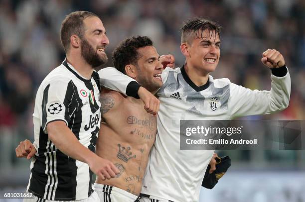 Paulo Dybala of Juventus FC celebrates with his team mates Daniel Alves da Silva and Gonzalo Higuain the victory at the end of the UEFA Champions...