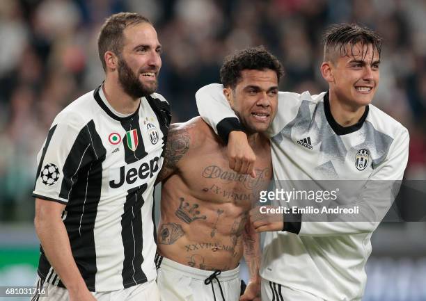 Paulo Dybala of Juventus FC celebrates with his team mates Daniel Alves da Silva and Gonzalo Higuain the victory at the end of the UEFA Champions...