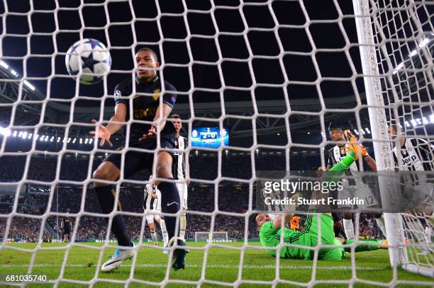 Gianluigi Buffon of Juventus looks back as Kylian Mbappe of AS Monaco picks the ball out of the net after he scores his sides first goal during the...