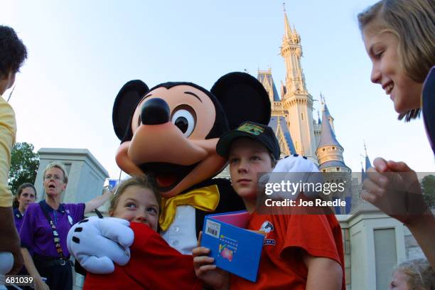 The Walt Disney character Mickey Mouse greets children at Magic Kingdom November 11, 2001 in Orlando, Florida.