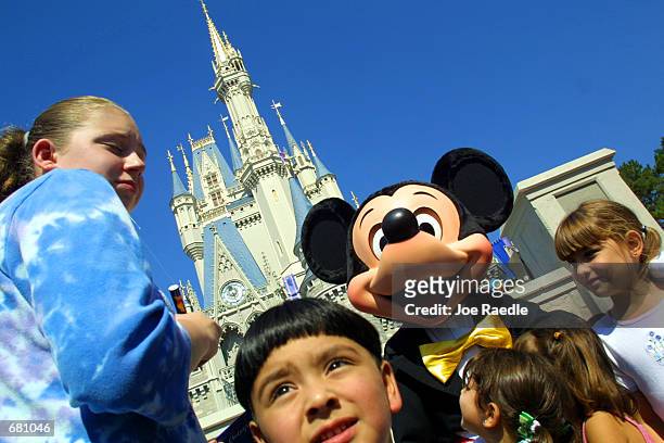 The Walt Disney character Mickey Mouse greets children in front of Cinderella's Castle at Magic Kingdom November 11, 2001 in Orlando, Florida.