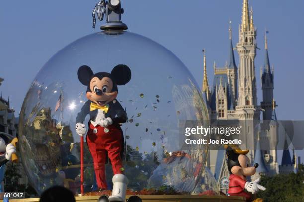 Mickey Mouse rides in a parade through Main Street, USA with Cinderella's castle in the background at Disney World's Magic Kingdom November 11, 2001...