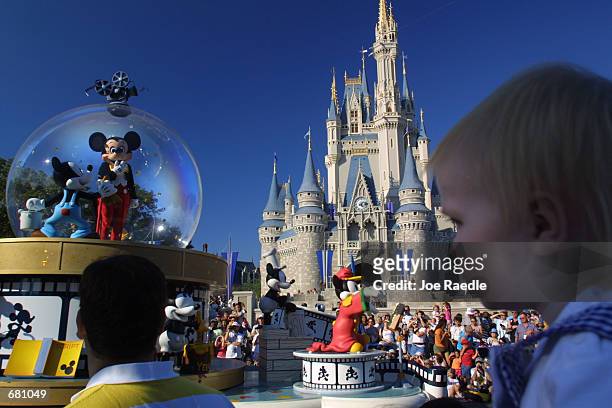 Mickey Mouse rides in a parade through Main Street, USA with Cinderella's castle in the background at Disney World's Magic Kingdom November 11, 2001...