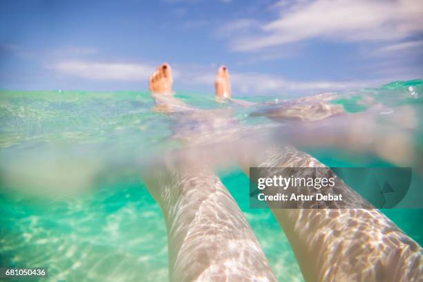 Traveler girl swimming and enjoying alone the beautiful beach during travel vacations in the Fuerteventura island with nice water colors, relaxing moment in stunning place with underwater view.