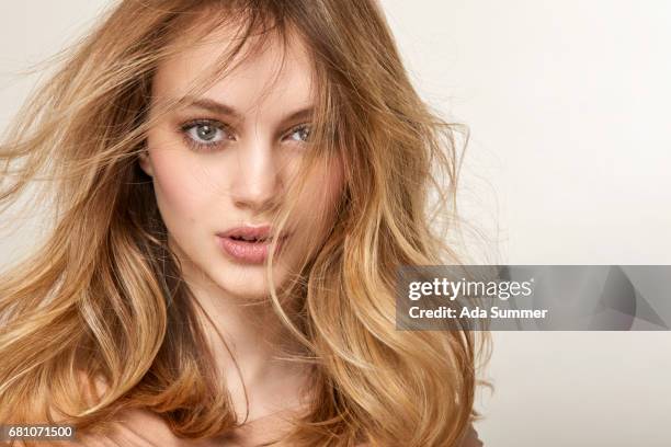 close up of a beautiful woman with windblown blonde hair - cabello desmelenado fotografías e imágenes de stock