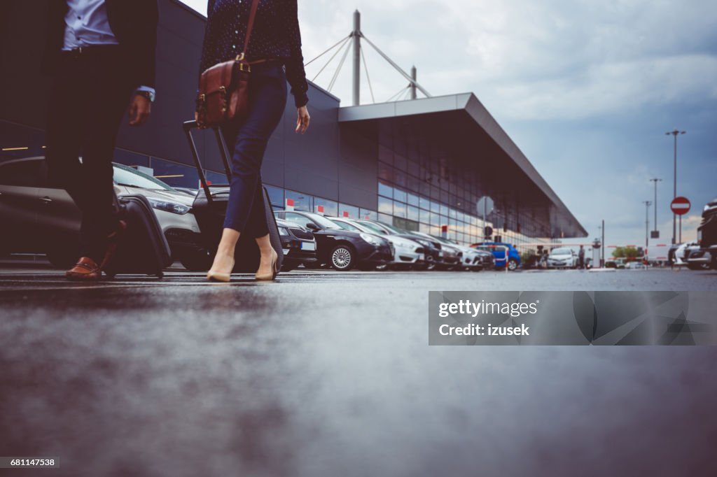 Dos empresarios en estacionamiento de aeropuerto