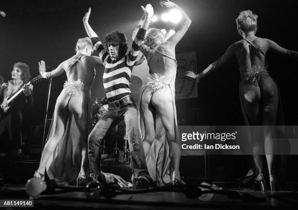 Zal Cleminson and Alex Harvey of The Sensational Alex Harvey Band performing on stage with dancers at New Victoria Theatre, London, 23 December 1975.
