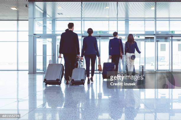 空港で荷物を持って歩く人のグループ - come ストックフォトと画像