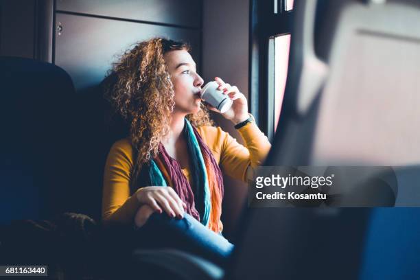 girl drinking coffeewhile commuting by train - coffee bag stock pictures, royalty-free photos & images