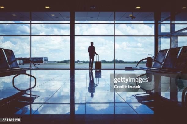 business man waiting to board a flight in airport - airport waiting lounge imagens e fotografias de stock