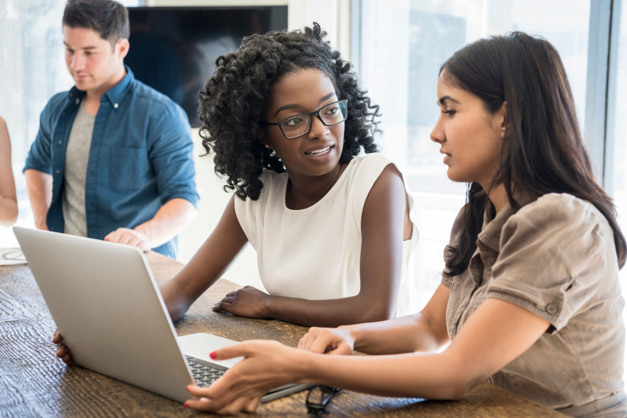 Two young businesswomen using laptop at work with serious expressions Two young businesswomen using laptop at work with serious expressions